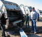 David watches the wood and trash go in the truck.