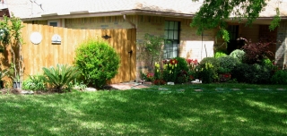 Lush landscapping decorates fence.